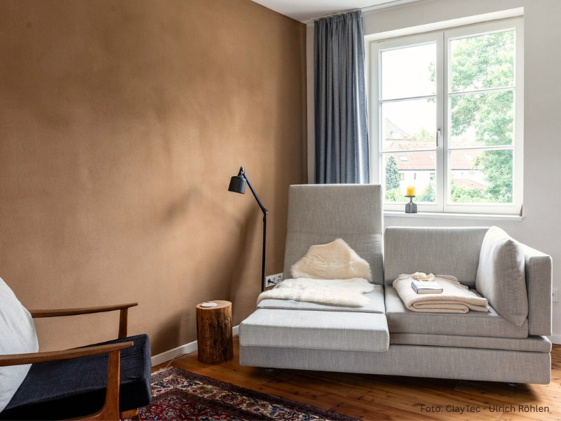 Yosima Lehm-Designputz von ClayTec mit schönen Lichtreflexen Yosima Lehm-Designputz von ClayTec in Braun im Wohnzimmer